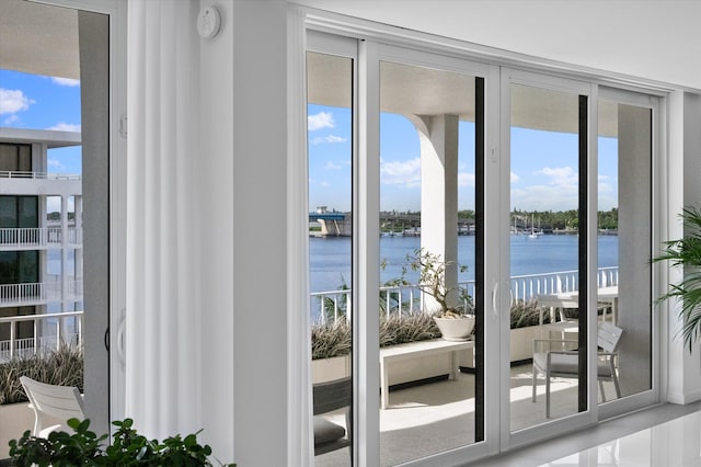 doorway featuring floor to ceiling windows and a water view