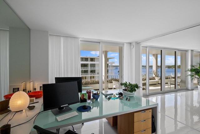 home office with floor to ceiling windows, plenty of natural light, and light tile patterned floors