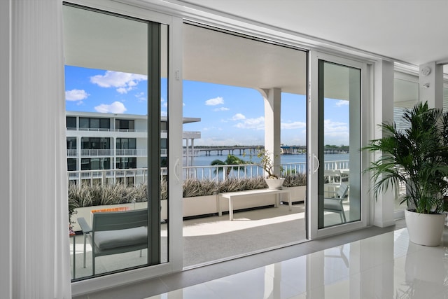 doorway to outside featuring a water view, a wall of windows, and tile patterned floors