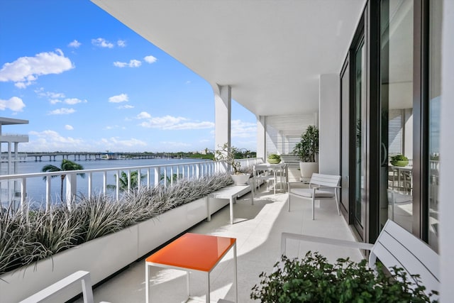 balcony featuring an outdoor living space and a water view