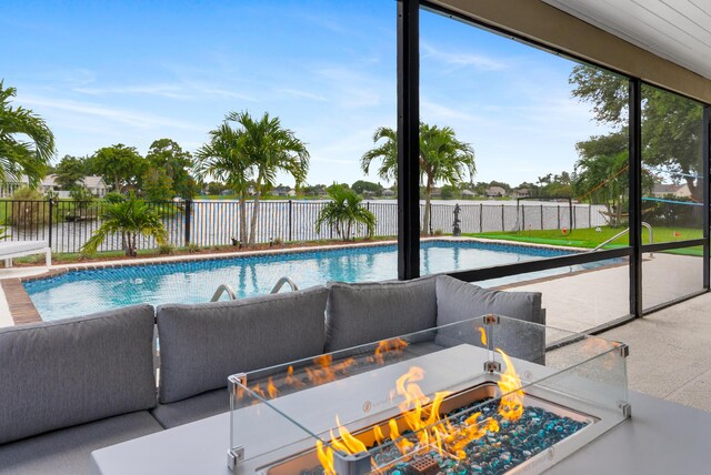 view of swimming pool with ceiling fan, a patio, and an outdoor living space with a fire pit