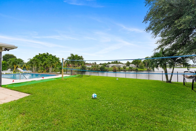 view of yard featuring a water view and a fenced in pool