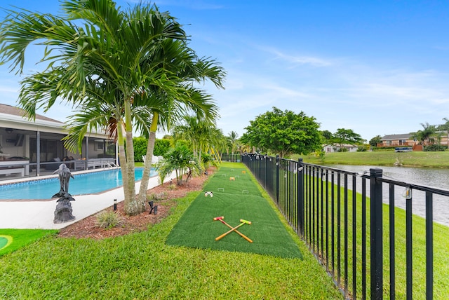 view of community featuring a water view, a swimming pool, and a yard