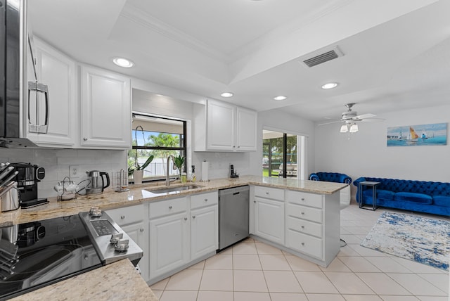 kitchen featuring appliances with stainless steel finishes, a healthy amount of sunlight, sink, and white cabinets