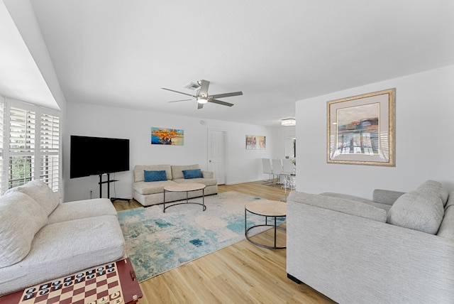 living room featuring hardwood / wood-style floors and ceiling fan