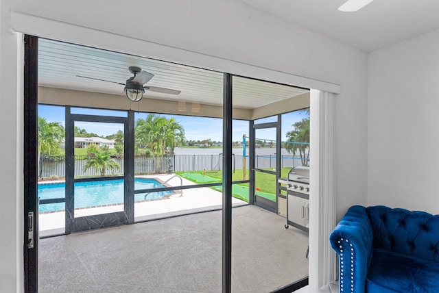 doorway featuring a water view, ceiling fan, and carpet flooring