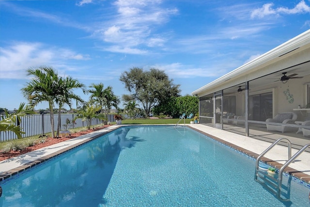 view of swimming pool with ceiling fan, a sunroom, and a patio