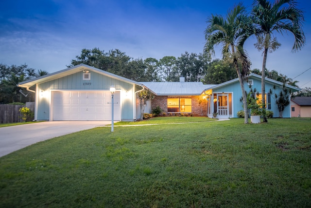 ranch-style house featuring a garage and a lawn