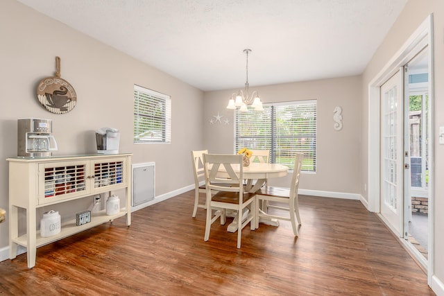 dining space with an inviting chandelier and dark hardwood / wood-style flooring