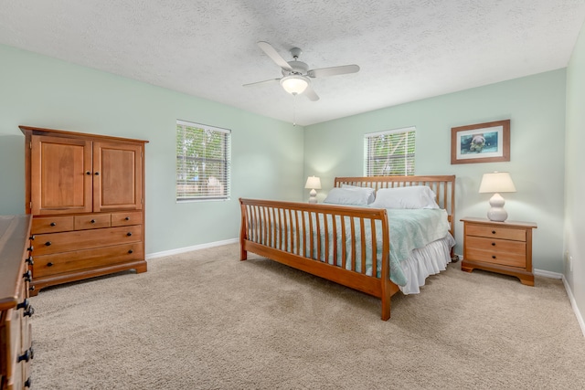 bedroom featuring ceiling fan, a textured ceiling, and light carpet