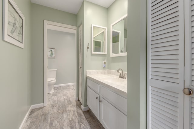 bathroom with vanity, hardwood / wood-style floors, and toilet