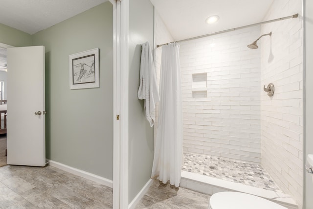 bathroom featuring toilet and curtained shower