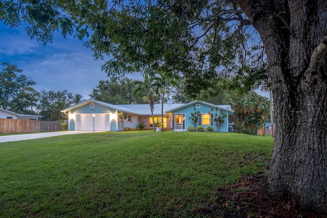 ranch-style house with a yard and a garage