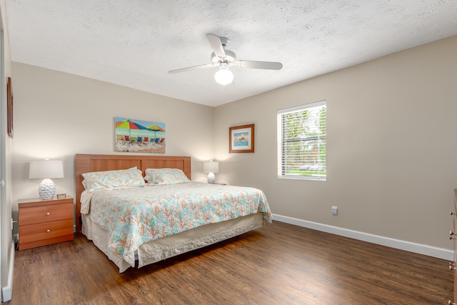 bedroom with ceiling fan, dark wood-type flooring, and a textured ceiling