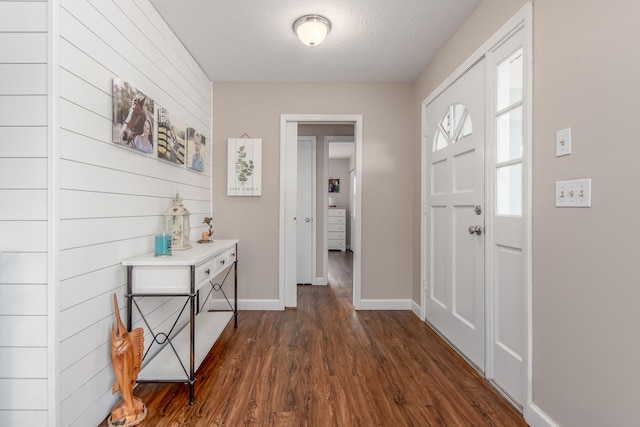 foyer featuring a textured ceiling and dark wood-type flooring