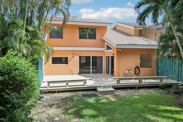 back of house with a wooden deck and a lawn