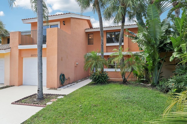 view of home's exterior featuring a lawn, a balcony, and a garage