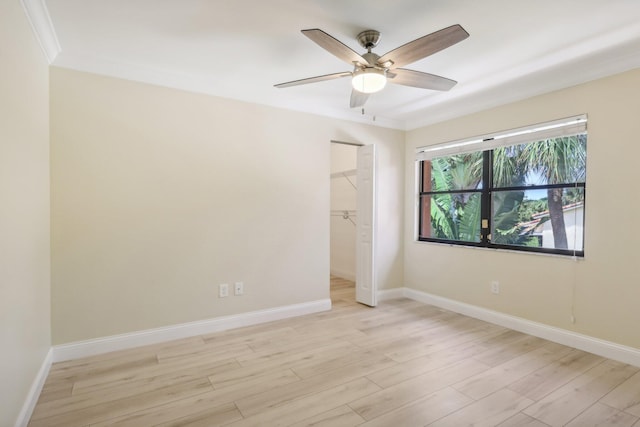 empty room featuring crown molding, light hardwood / wood-style flooring, and ceiling fan