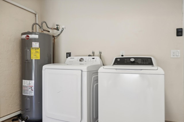 laundry room with water heater and washer and dryer