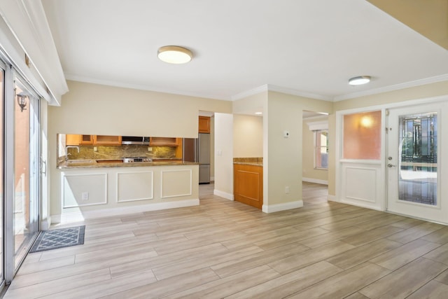 unfurnished living room with ornamental molding and light hardwood / wood-style flooring