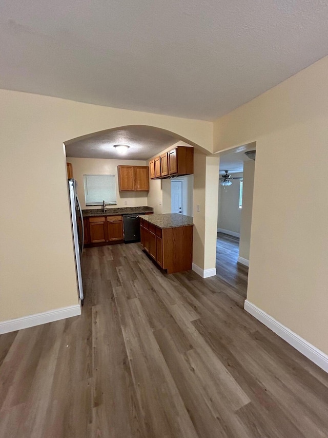 kitchen with ceiling fan, stainless steel refrigerator, dark wood-type flooring, sink, and dishwasher