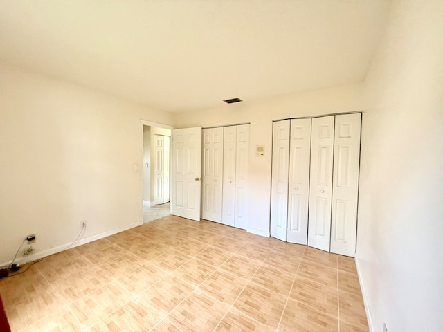 unfurnished bedroom with multiple closets