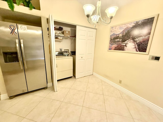 washroom with washer / dryer, a notable chandelier, and light tile patterned floors