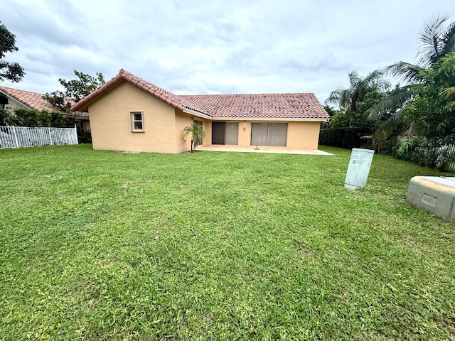 back of house featuring a patio area and a lawn