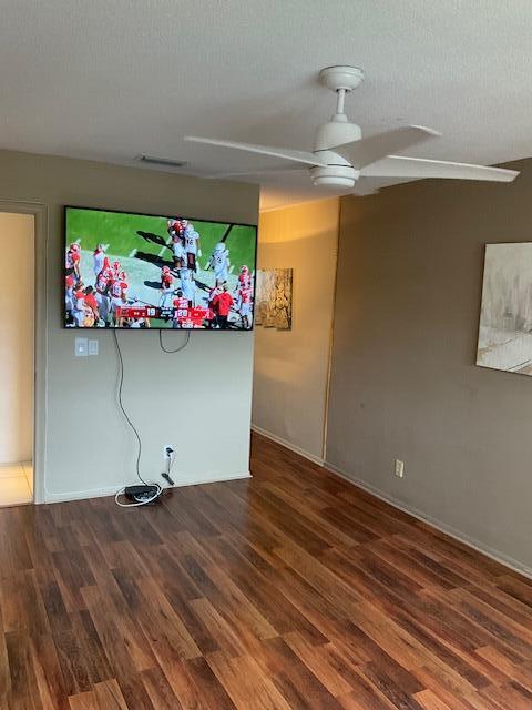 interior space with ceiling fan, dark wood-type flooring, and a textured ceiling