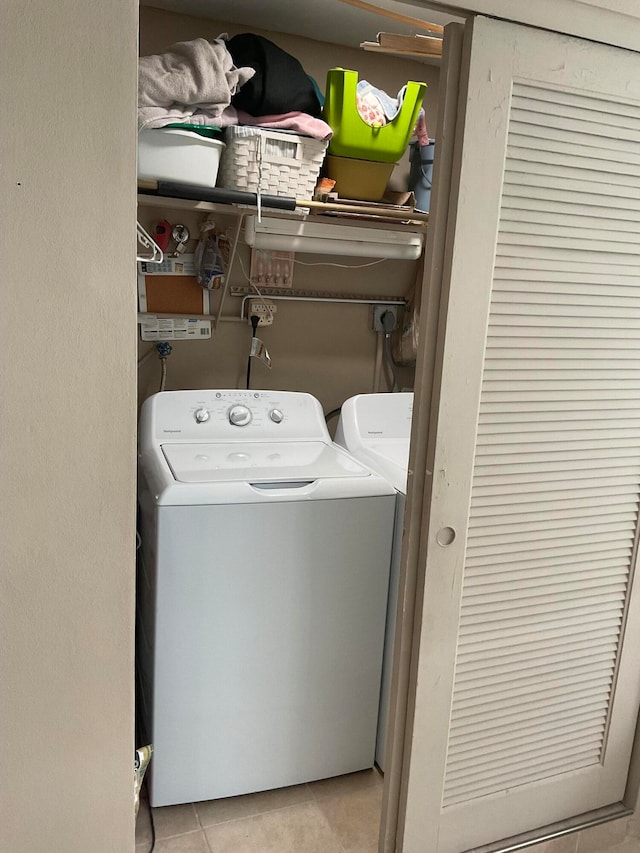 laundry room with independent washer and dryer and light tile patterned floors