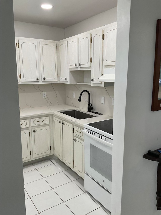 kitchen with decorative backsplash, white range, sink, light tile patterned floors, and range hood