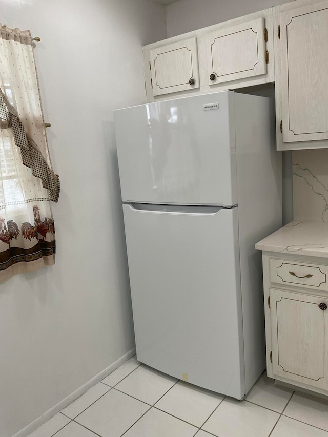 kitchen featuring light tile patterned floors and white fridge