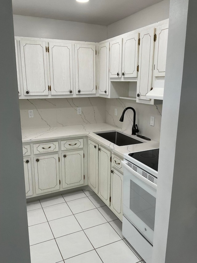 kitchen with decorative backsplash, ventilation hood, sink, light tile patterned floors, and white stove