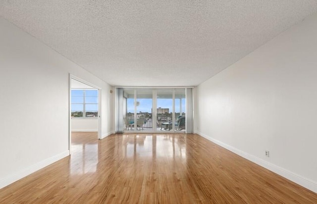 spare room featuring light hardwood / wood-style floors and a textured ceiling