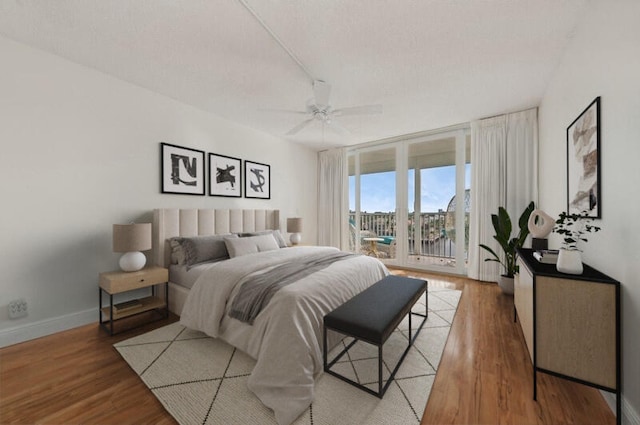 bedroom featuring access to outside, hardwood / wood-style floors, and ceiling fan