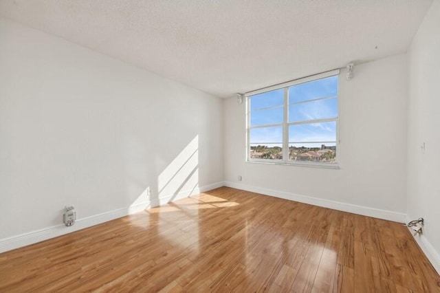 spare room with a textured ceiling and wood-type flooring