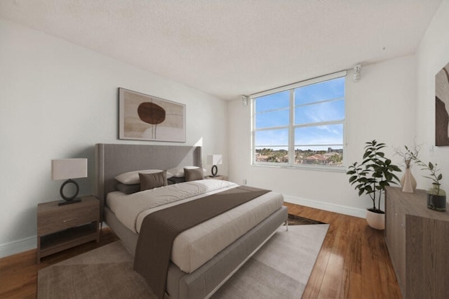 bedroom featuring hardwood / wood-style floors and a textured ceiling