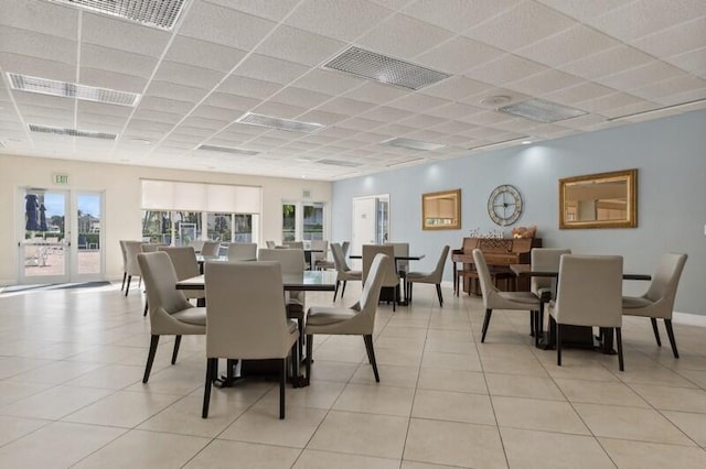 dining room featuring a drop ceiling and light tile patterned floors