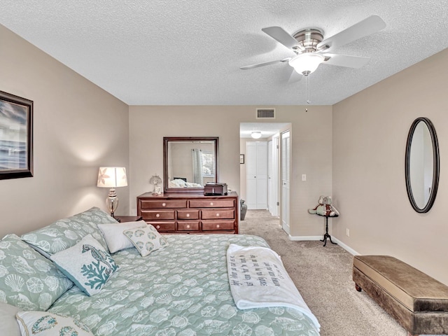 carpeted bedroom featuring a textured ceiling and ceiling fan