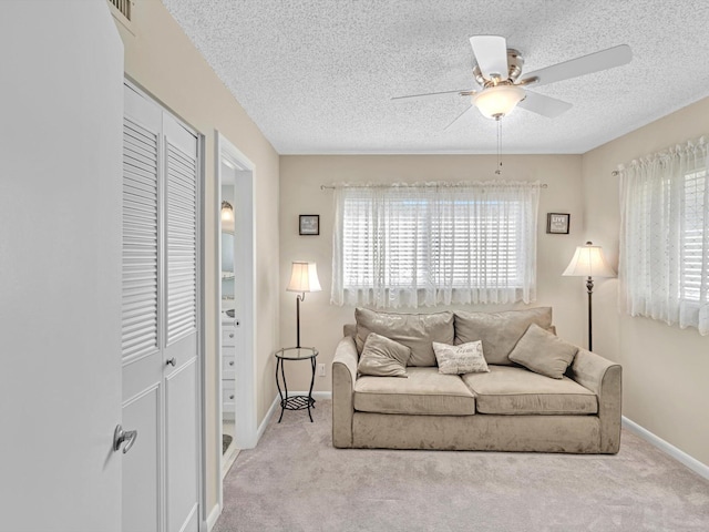 carpeted living room featuring ceiling fan and a textured ceiling