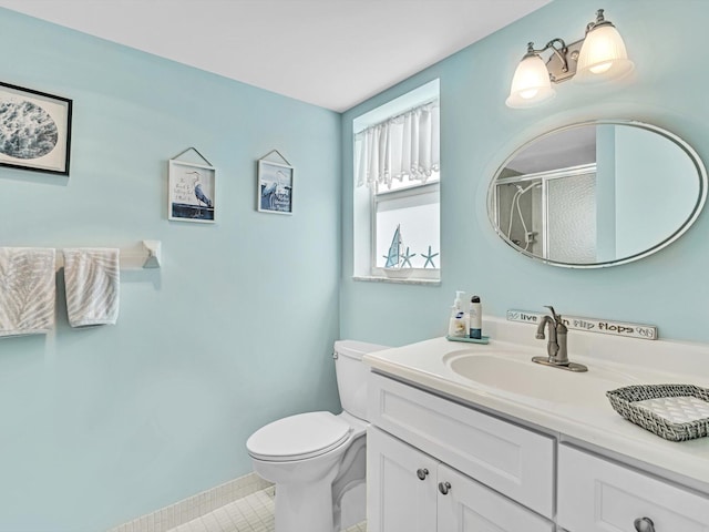 bathroom featuring tile patterned floors, vanity, toilet, and walk in shower