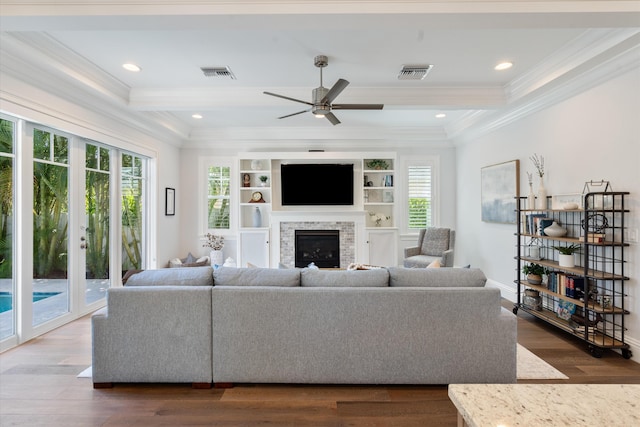 living room with a wealth of natural light, ornamental molding, and dark wood-type flooring