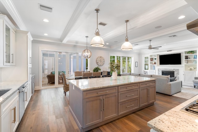 kitchen with dark hardwood / wood-style floors, beamed ceiling, hanging light fixtures, white cabinetry, and a fireplace