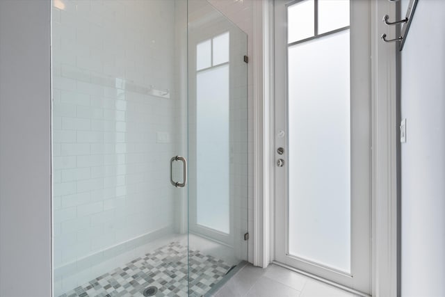 bathroom featuring tile patterned floors and a shower with shower door