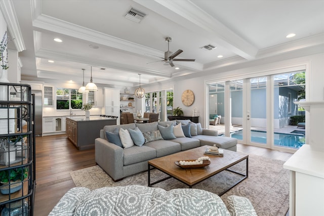 living room featuring sink, ceiling fan, beamed ceiling, dark wood-type flooring, and crown molding