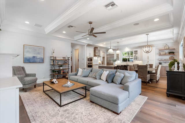 living room with crown molding, beam ceiling, light hardwood / wood-style flooring, and ceiling fan with notable chandelier