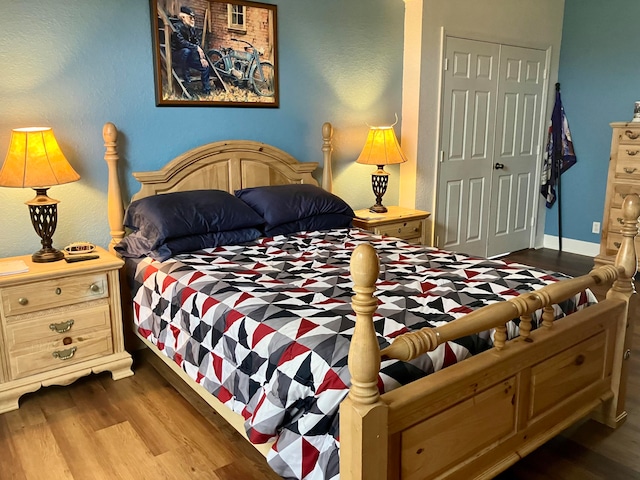 bedroom with wood-type flooring and a closet