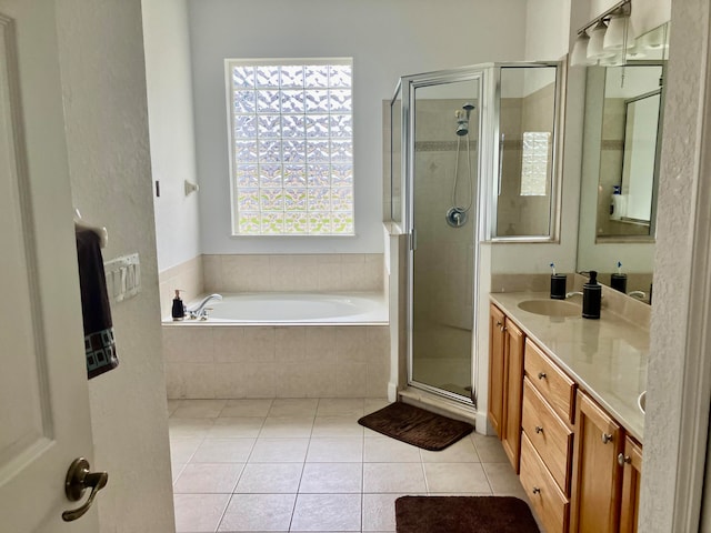 bathroom featuring tile patterned flooring, vanity, and shower with separate bathtub