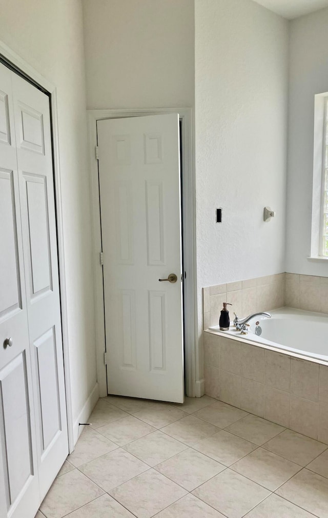 bathroom with tiled bath and tile patterned flooring