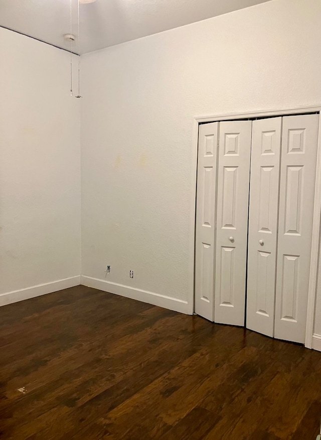 unfurnished bedroom featuring a closet and dark hardwood / wood-style floors